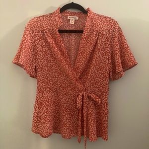 Monteau size large orange blouse with tie and white flowers